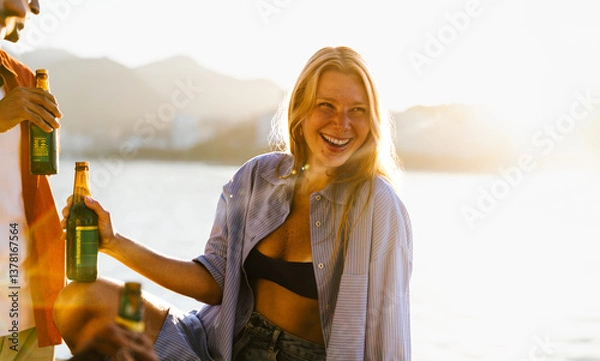 Fototapeta Friends enjoying drinks at sunset during a magical summertime evening