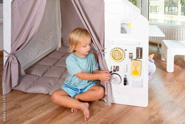 Fototapeta A toddler explores a vibrant indoor playhouse with cheerful beige accents, sparking imagination and playful creativity in a safe and cozy environment.