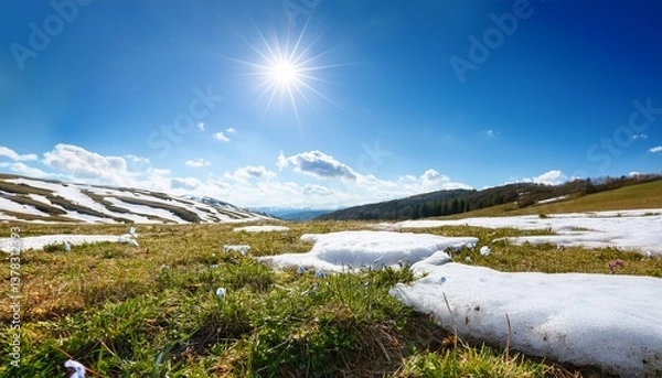 Obraz idyllic spring meadow with melting snow patches and vibrant blue sky under the warm sun