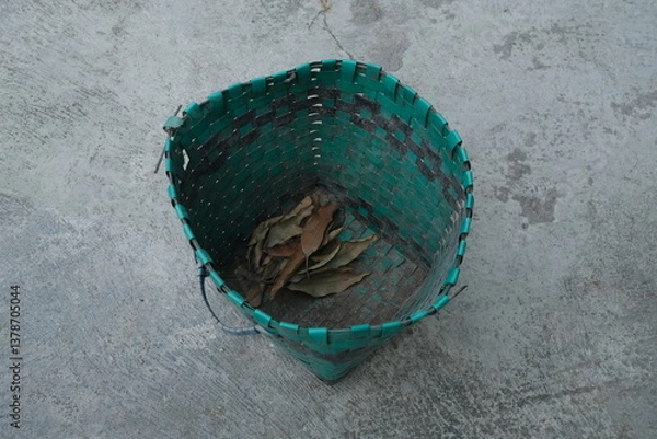 Fototapeta photo of a green trash can on the ground