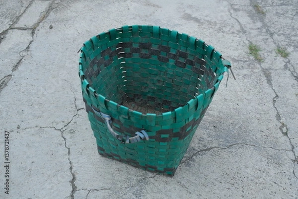 Fototapeta photo of a green trash can on the ground