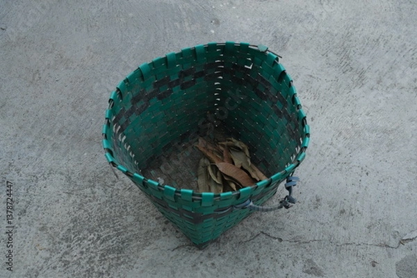 Fototapeta photo of a green trash can on the ground