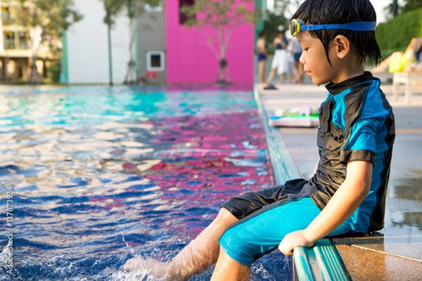 Fototapeta boy learn to swim in the swimming pool