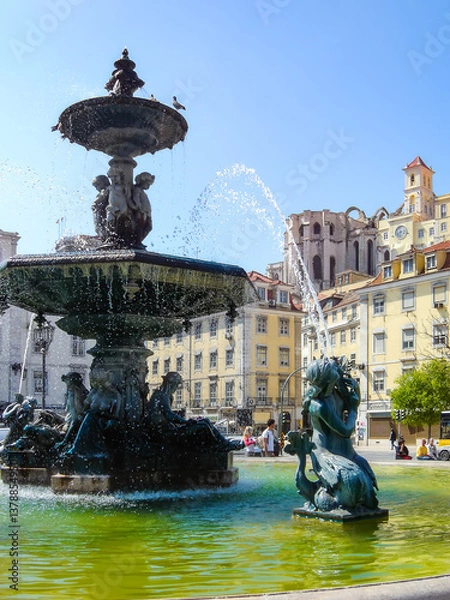 Fototapeta Lisbon, Portugal. Close-up on one of the two bronze fountains with mermaids and water jets. Rossio Square or Dom Pedro IV Square.