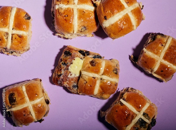 Fototapeta Top view of some hot cross buns with a purple background.