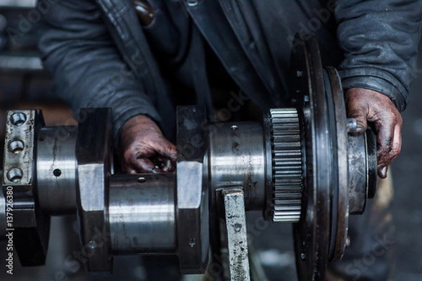 Fototapeta Working hand in the engine oil with the tools