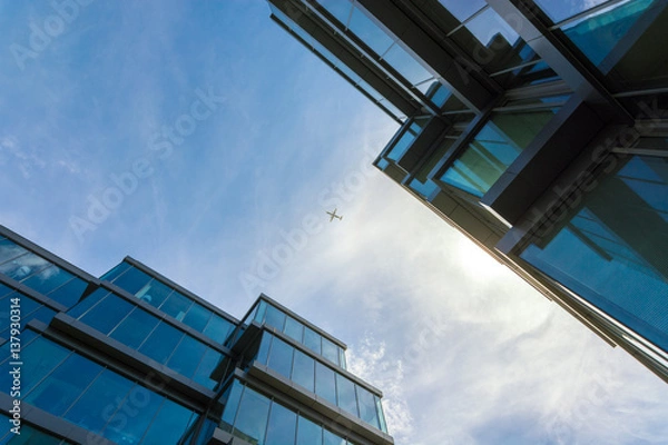 Obraz an airplane between two office buildings