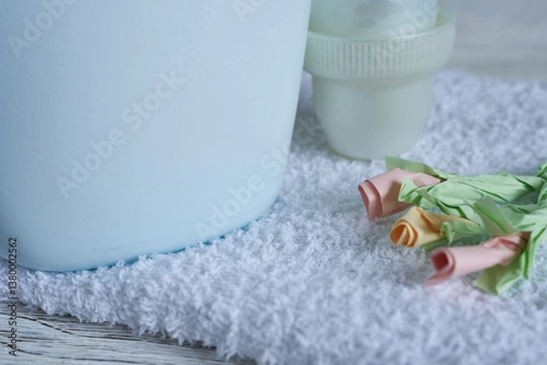 Fototapeta Laundry conditioner and towels on wooden background. Selective focus.