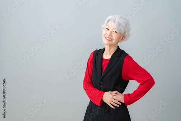 Fototapeta グレーバックのシニアの女性