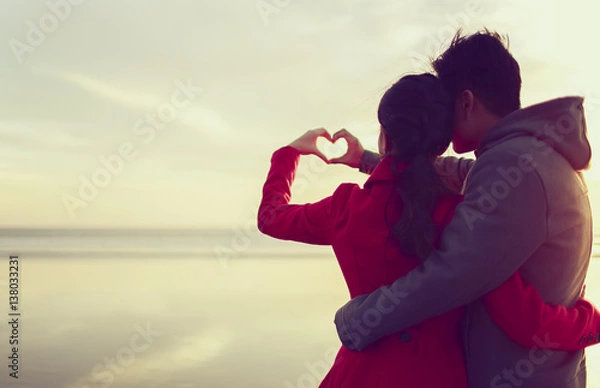 Fototapeta Young couple making a heart shape by hands 
