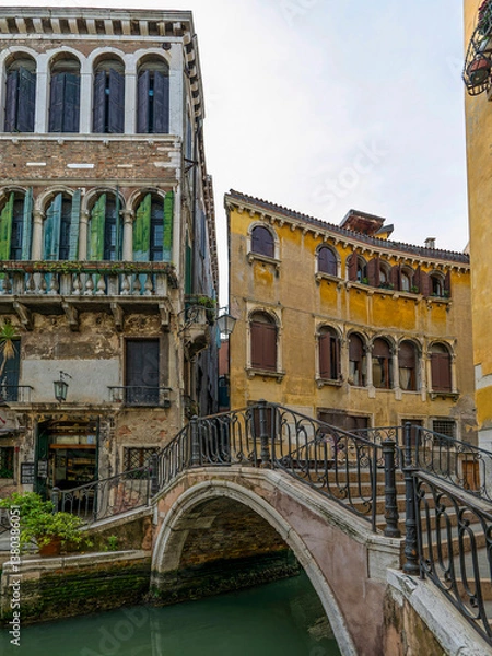 Obraz A glimpse of Calle Larga and its bridge over a Venetian canal, capturing the essence of the city’s historic architecture, and captivating atmosphere. Travel in Italy.