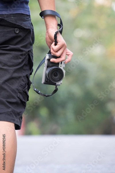 Obraz photographer holding camera, close-up. Back view, Selective focus