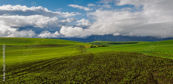 Obraz Mountain landscape. A view of the green hills with storm clouds looming over them.