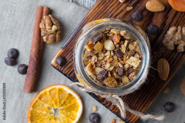 Obraz Homemade granola with nuts and dried oranges in jar, top view