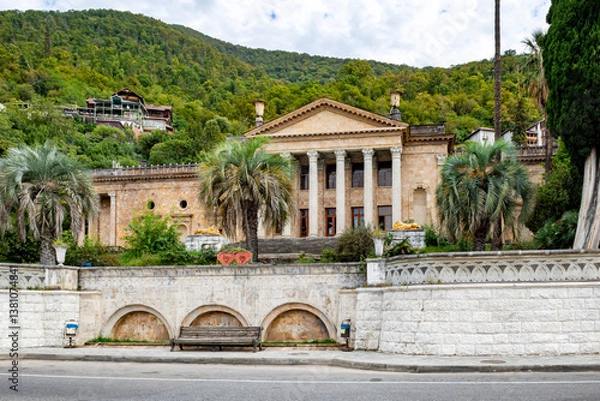 Fototapeta Gagra, Abkhazia-October 11 2024 : Old historical building with columns among the mountains in the Republic of Abkhazia. Building of the Winter Theater in Gagra. Sunny autumn day