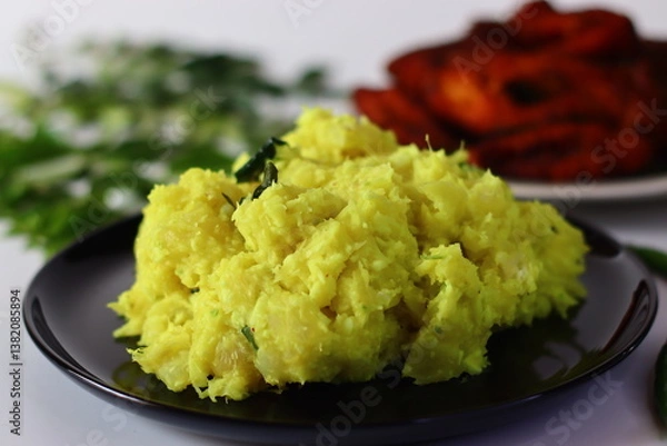 Obraz Boiled and mashed tapioca mixed with turmeric, chilies and curry leaves, served alongside fried fish