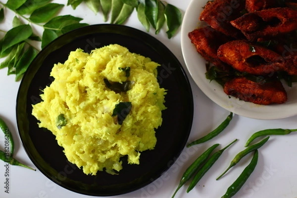 Obraz Boiled and mashed tapioca mixed with turmeric, chilies and curry leaves, served alongside fried fish