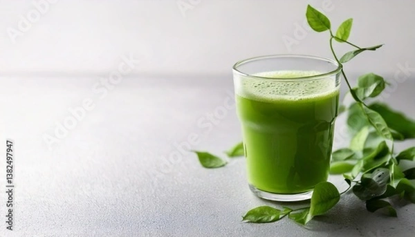 Obraz A bright green glass of matcha green tea is placed on a clean white surface. Matcha powder is sprinkled around it. It is perfect for use as a promotional image for health drinks or content related to 
