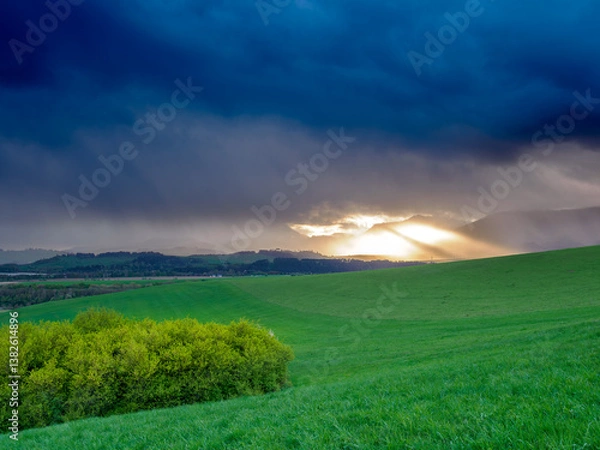 Obraz Mountain landscape. A view of the green hills with storm clouds looming over them. You can see the approaching rain from the clouds