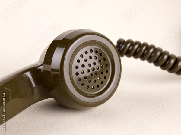 Obraz Gros plan sur un combiné entier d'un téléphone marron à cadran rotatif, sur fond beige clair.