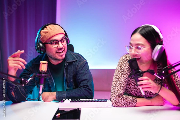 Fototapeta Teenagers, men and women, host podcasts in a room using LED lights, computers, headphones, condenser microphones, and tablets to share their knowledge and experiences through live online broadcasts.