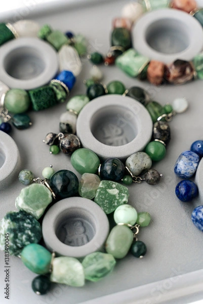 Obraz Jewelry-making board with natural stone bracelets. Assorted gemstone bracelets and raw crystals for crafting. Handmade stone bead bracelets.