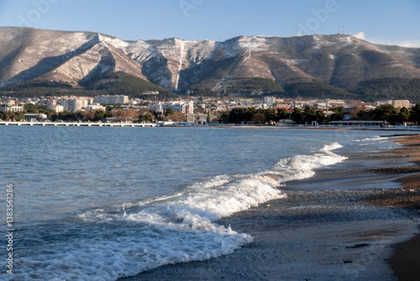 Obraz A beautiful mountain range with a city in the background. The city is full of buildings and the water is calm