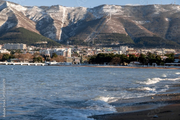 Obraz A beautiful mountain range with a city in the background. The city is full of buildings and the water is calm