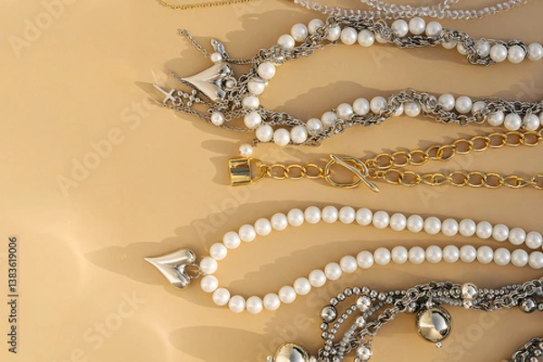 Obraz Elegant pearl and silver charm necklaces on beige background.  .Fashionable layered silver necklaces with pendants and with silver heart pendant