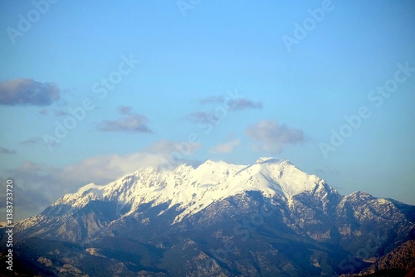 Obraz High impregnable mountains with large white snow caps on tops under blue sky with some clouds