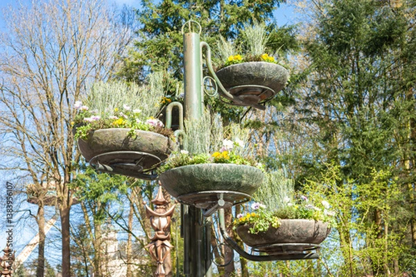 Obraz Decorative column with baskets filled with spring flowers