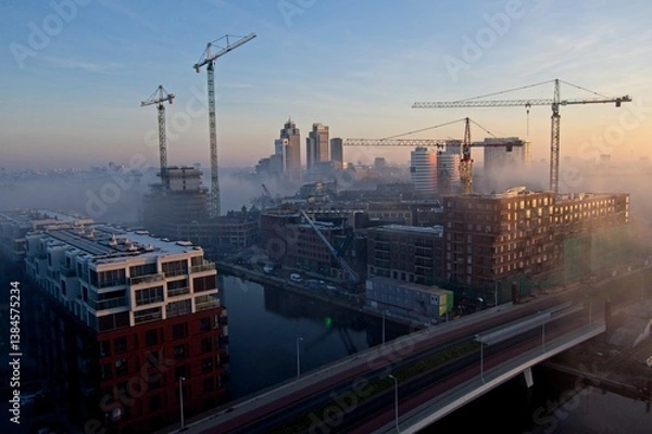 Fototapeta Amsterdam Netherlands - 27 March 2025 - Birds eye view of building site in Amsterdam Overamstel in the early morning - redevelopment of an industrial area into a residential area
