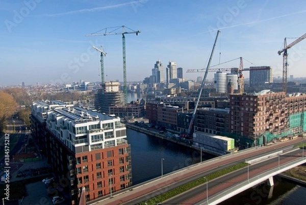 Fototapeta Amsterdam Netherlands - 27 March 2025 - Birds eye view of building site in Amsterdam Overamstel in the early morning - redevelopment of an industrial area into a residential area