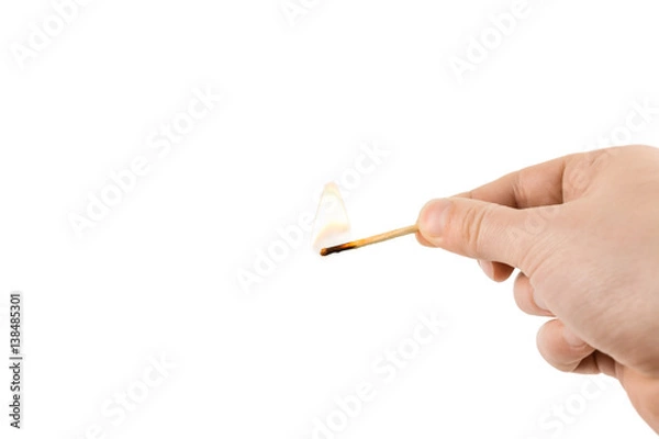 Fototapeta burning match in the hand isolated on white background