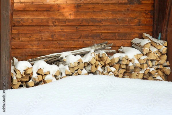 Fototapeta Chopped and stacked birch firewood covered with snow