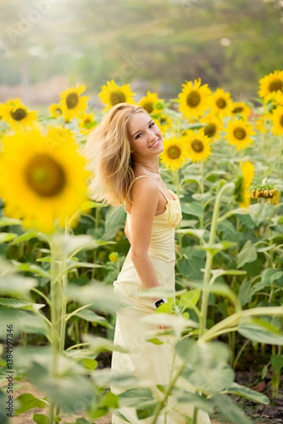 Obraz Cute european young model girl posing and having fun in a field full of blooming sun flowers. Showing freedom, innocence and youth