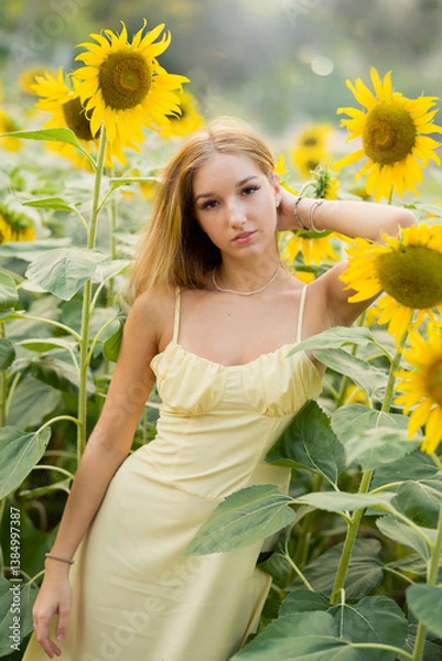 Obraz Cute european young model girl posing and having fun in a field full of blooming sun flowers. Showing freedom, innocence and youth