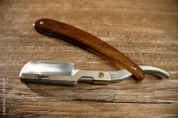Fototapeta Old fashioned straight razor on wooden surface