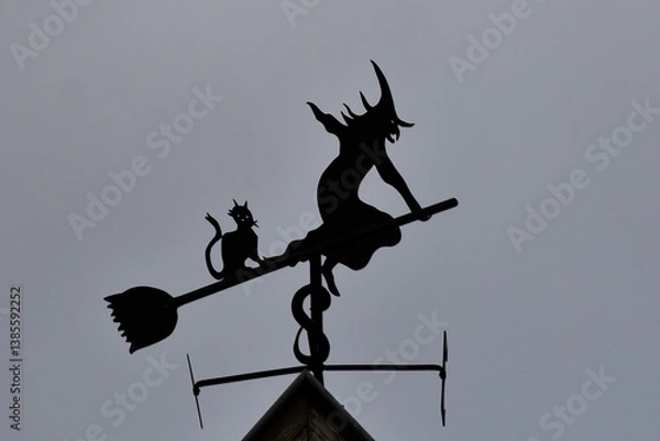 Fototapeta Girouette en forme de sorcière volant sur un balai sur le toit d’une maison de Bergheim en Alsace