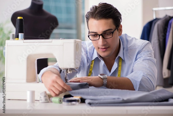 Fototapeta Young man tailor working on new clothing