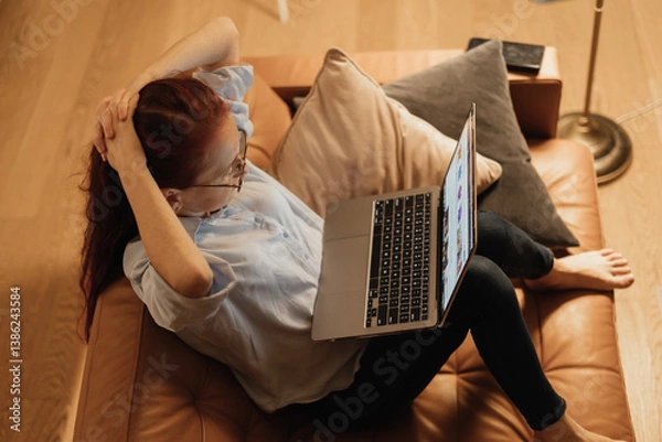 Obraz Relaxing Evening Online: Woman Browsing on Laptop in a Cozy Home Setting