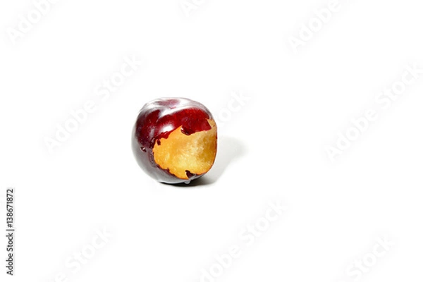 Fototapeta a fresh blue plum with a bite mark, isolated on white background