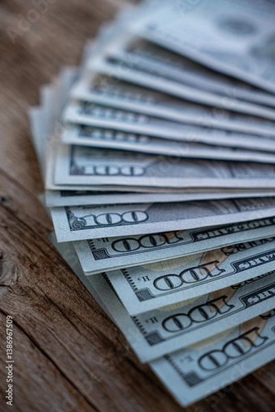 Fototapeta Stacks of hundred dollar bills on a wooden surface