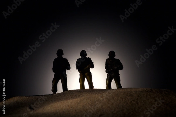 Fototapeta Silhouette of soldiers on a dark background
