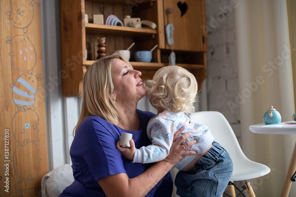Fototapeta Grandmother with grandson boy at home. Relatives bonding and generational communication. Old lady and child having fun together.