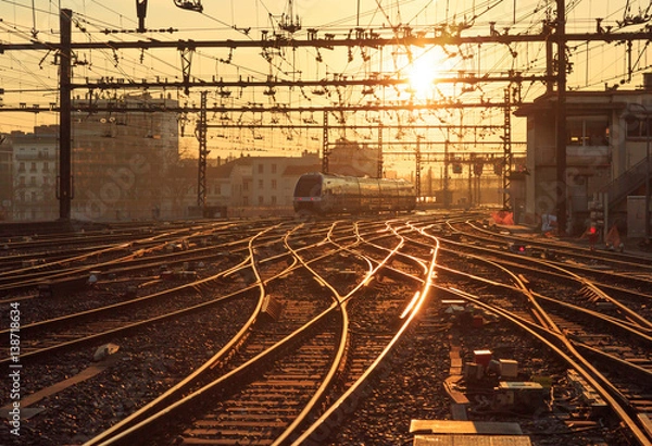 Fototapeta Pociąg na torach kolejowych na stacji Perrache w Lyonie (Gare de Lyon-Perrache) we Francji, o wschodzie słońca.