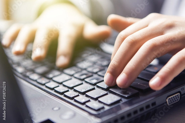 Fototapeta Technology, typing on a laptop keyboard (glare, flare)