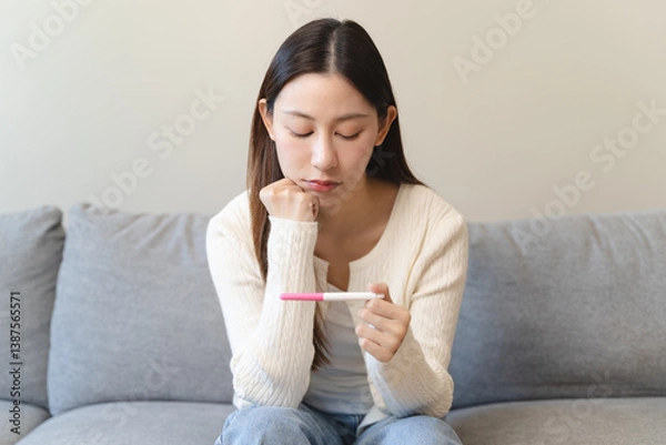 Fototapeta Close-up young woman checking on the pregnancy test and the result is positive.