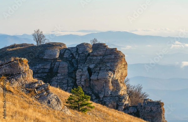 Obraz Mountain view over a sea of clouds in morning light, with rock formations and dry grass