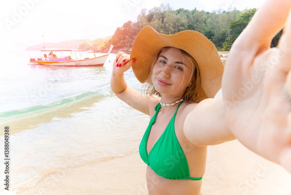 Obraz Travel selfie Young caucasian female relaxing on tropical beach in green bikini and hat